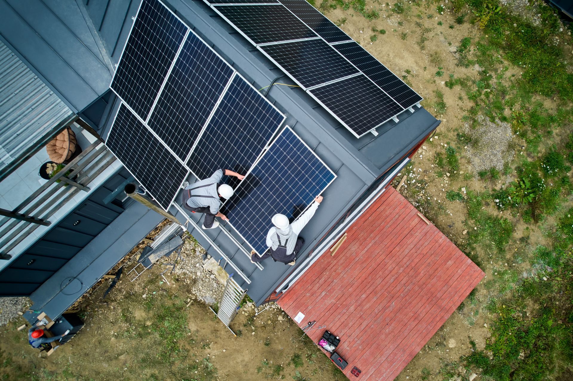 An aerial view of a house with solar panels on the roof.