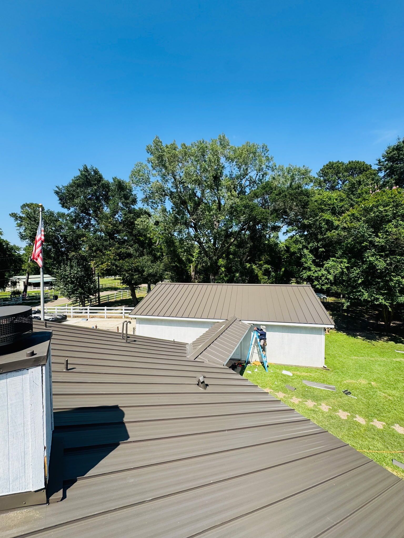 Rooftop view with a shed and flag under a clear blue sky.