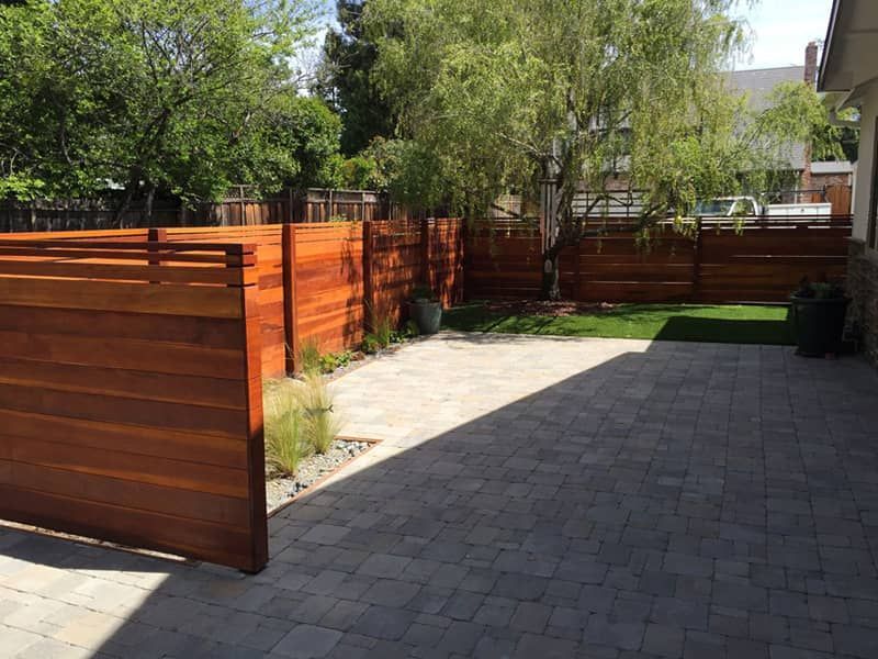 There is a wooden fence in the backyard of a house.
