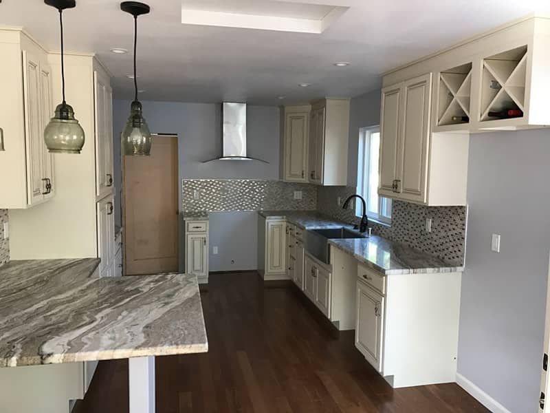 A kitchen with white cabinets and granite counter tops