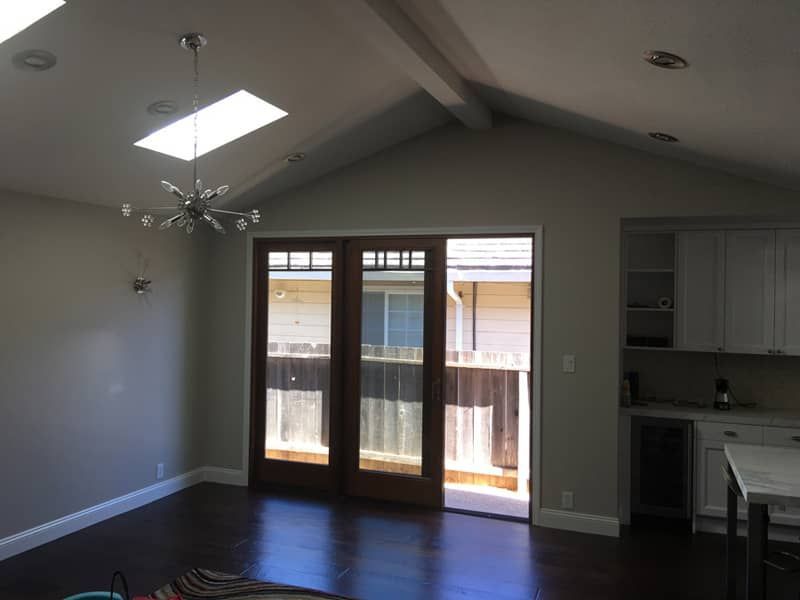 A living room with a skylight and sliding glass doors