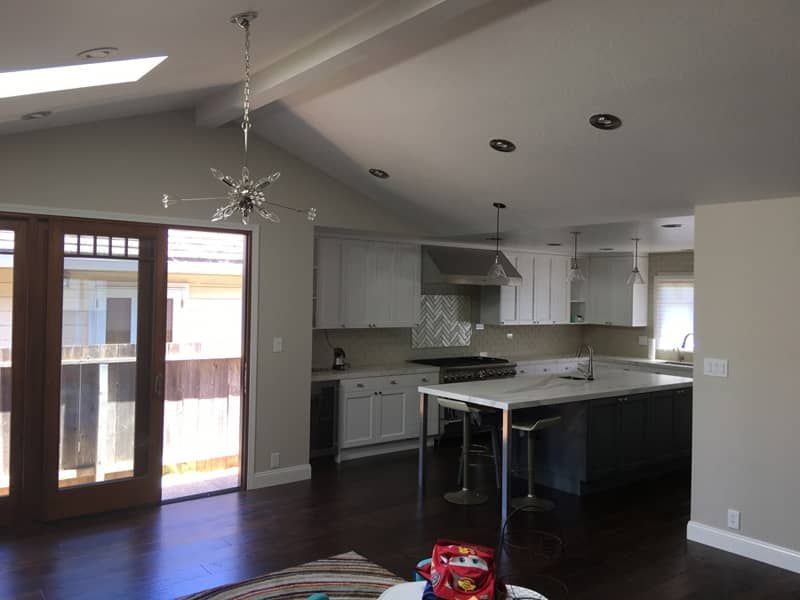 A kitchen with white cabinets and a large island