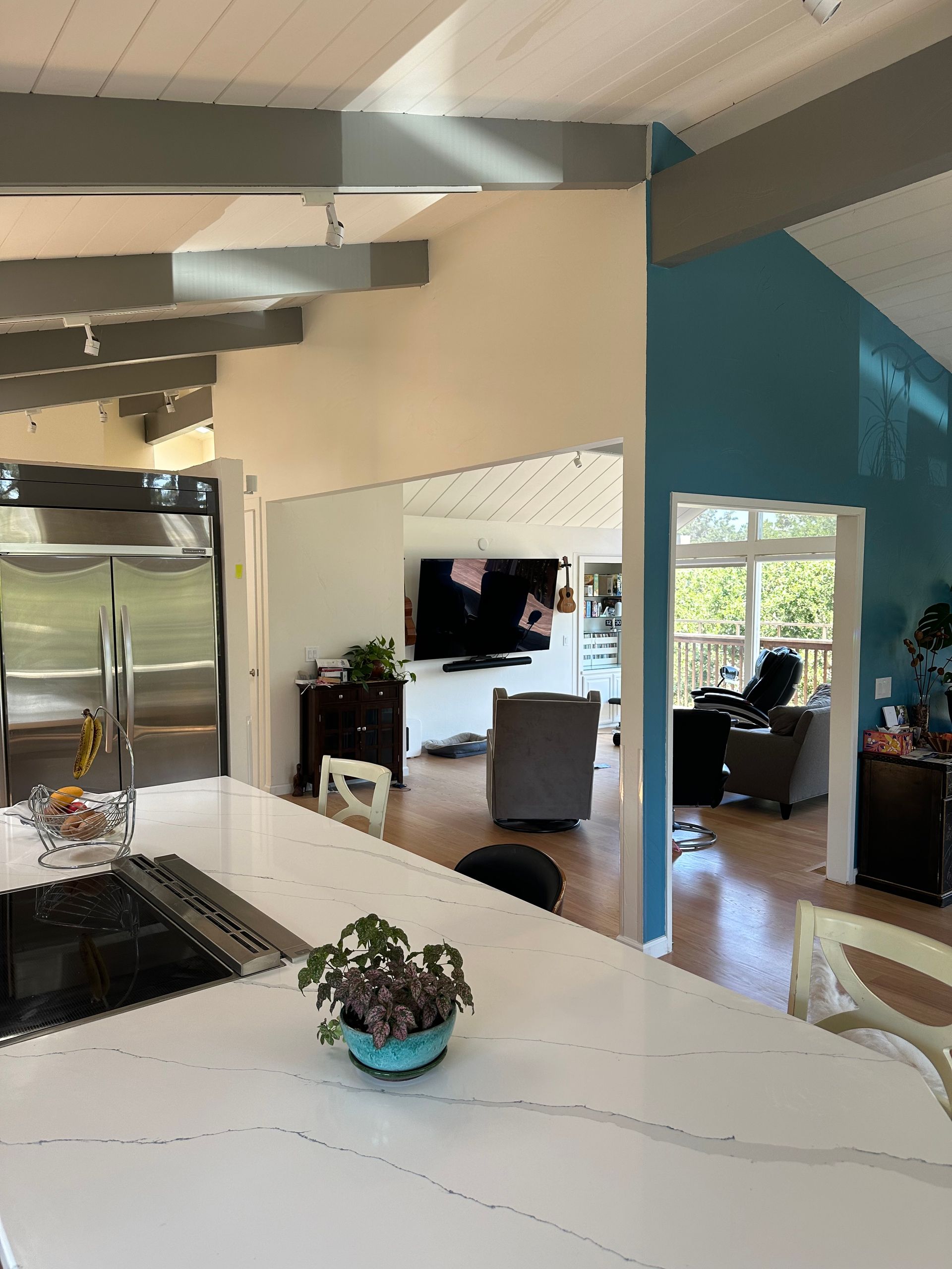 A kitchen with a white counter top and a potted plant on it