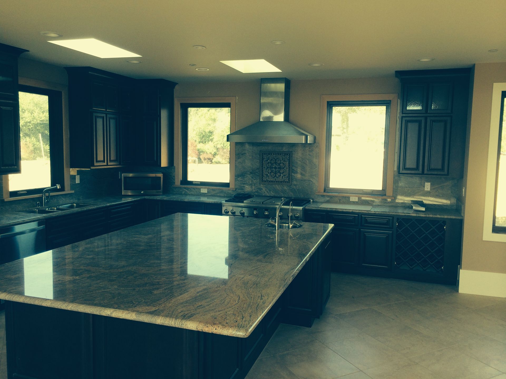 A kitchen with granite counter tops and black cabinets