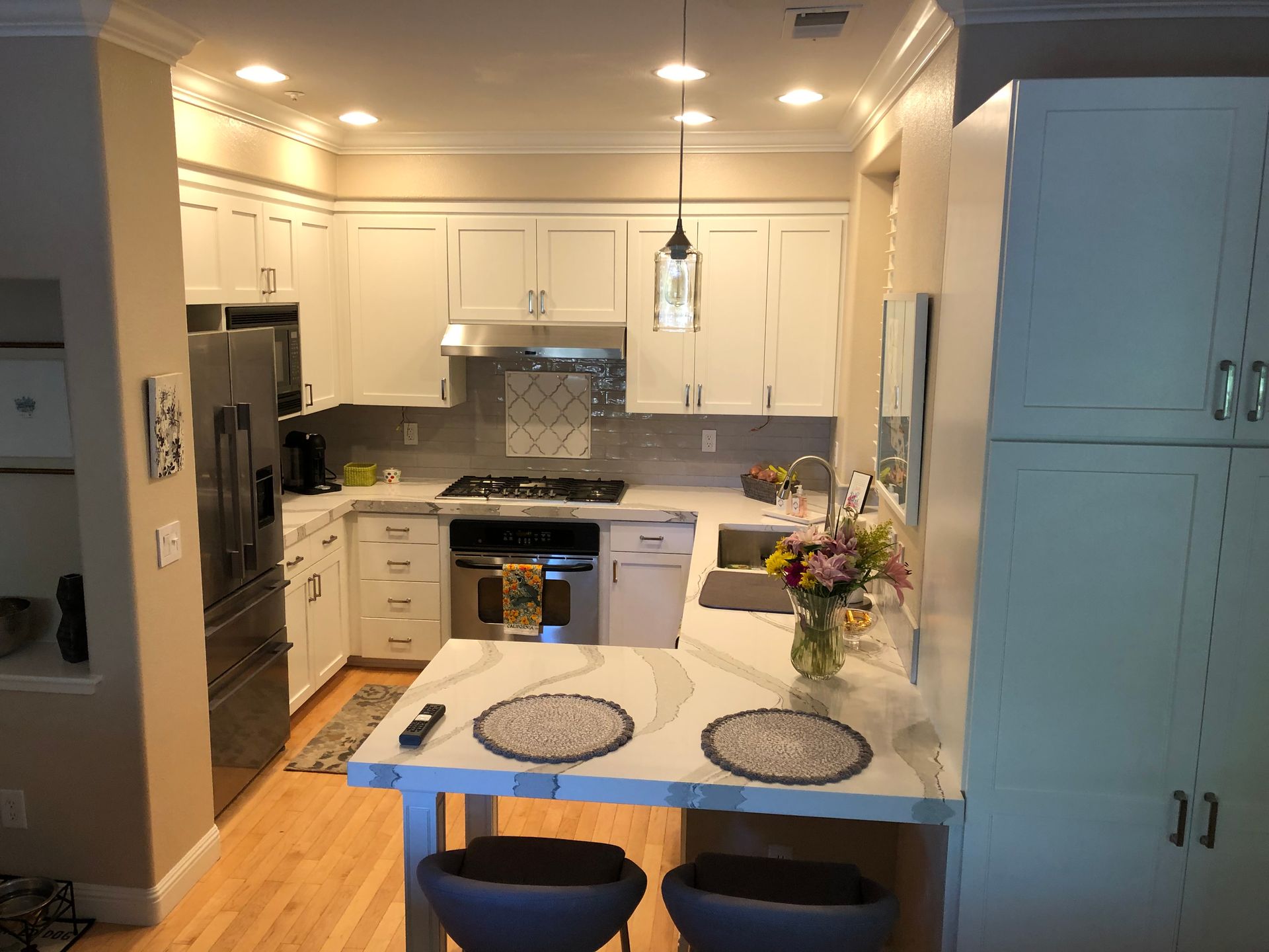 A kitchen with white cabinets and stainless steel appliances