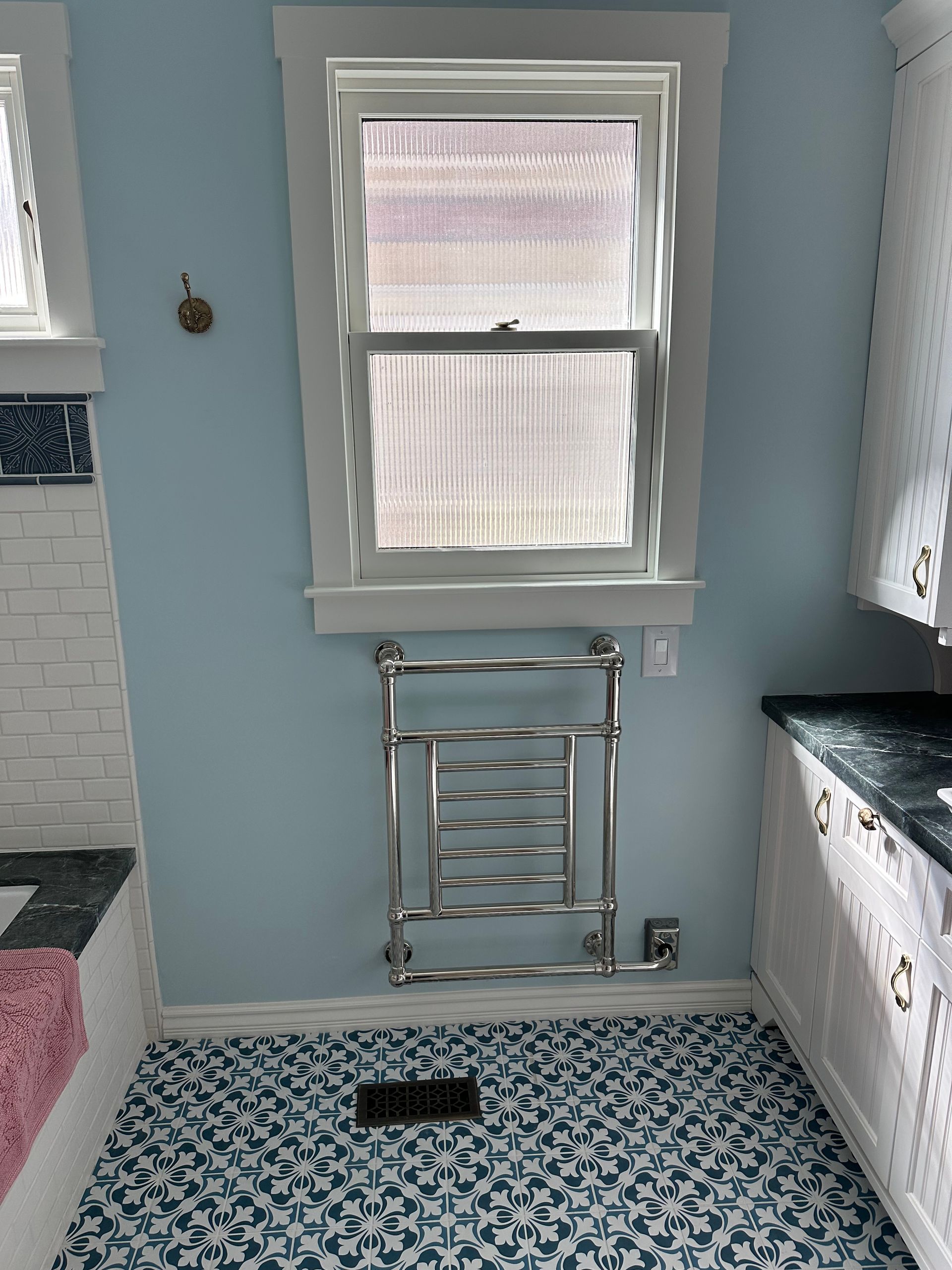 A bathroom with a towel rack and a window