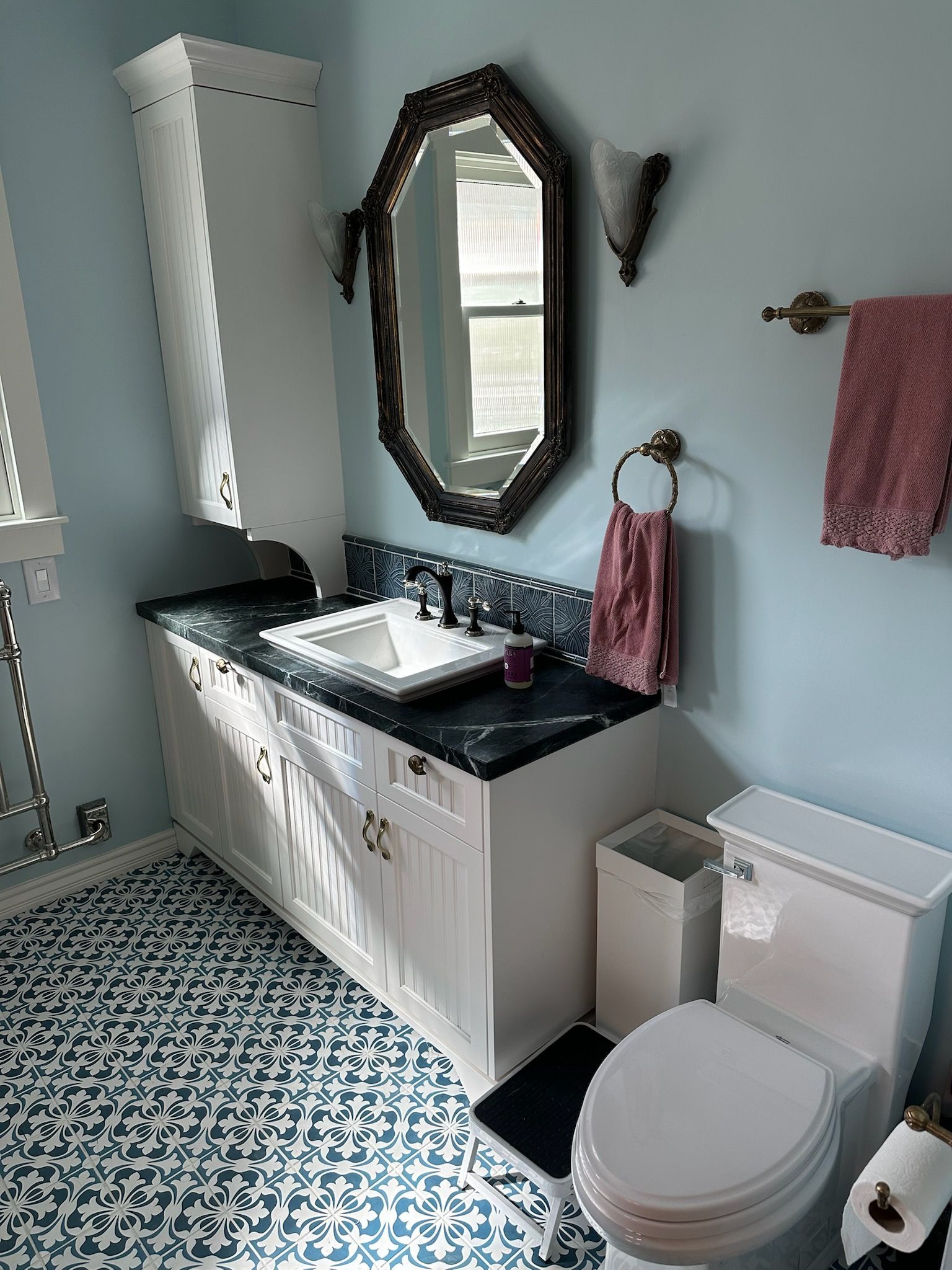 A bathroom with a sink , toilet and mirror.