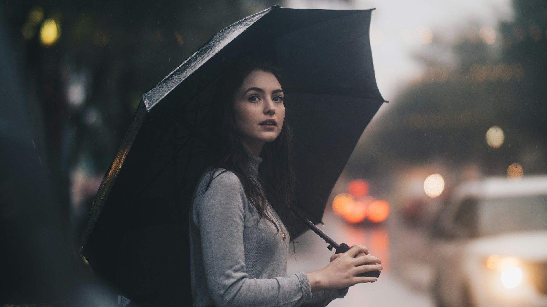A woman is holding an umbrella in the rain.
