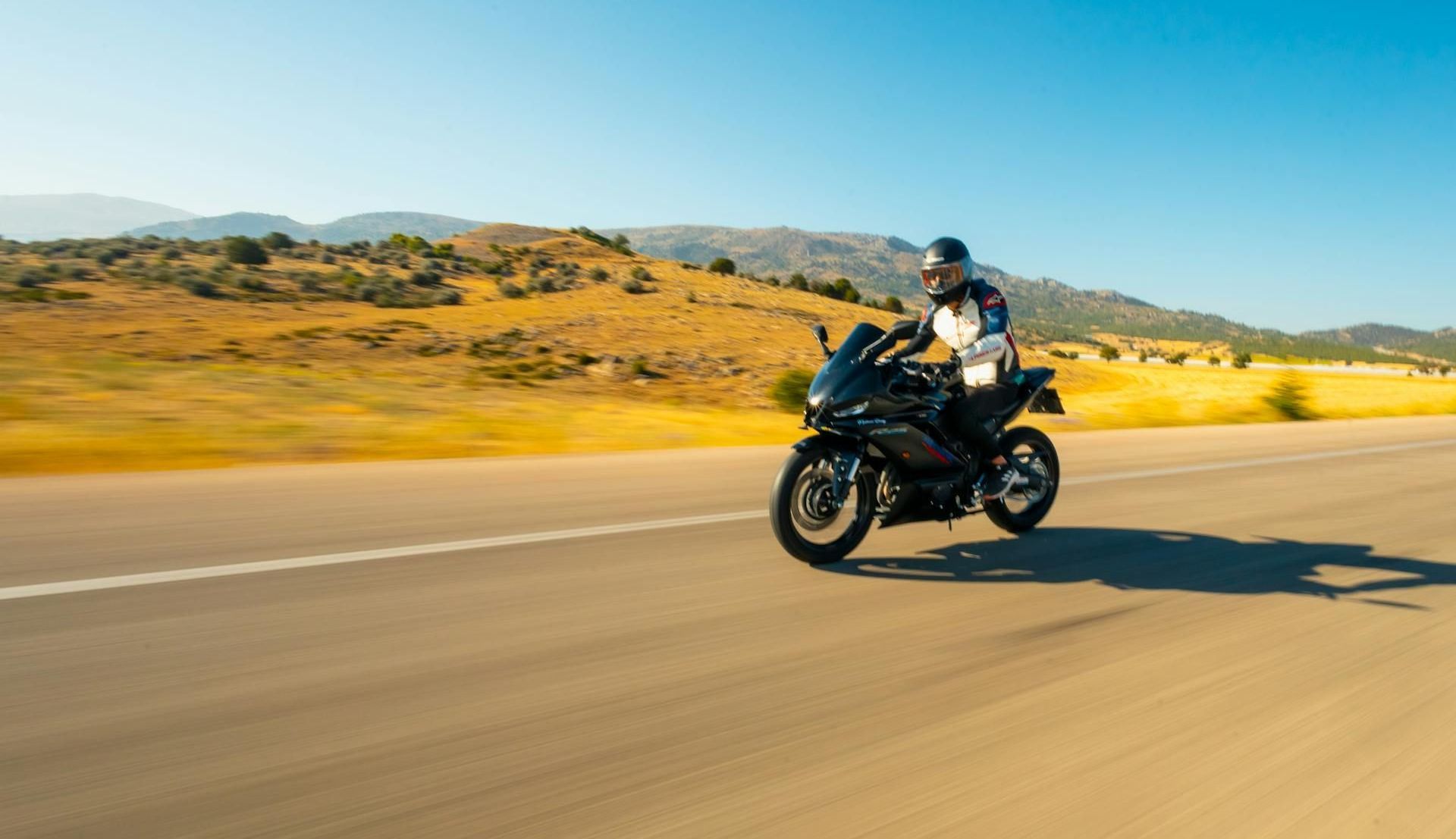 A man is riding a motorcycle down a road.