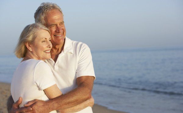 Senioren-Paar umarmt sich am Strand
