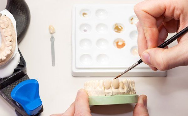 Zahntechniker bemalt Zahnkrone aus Keramik