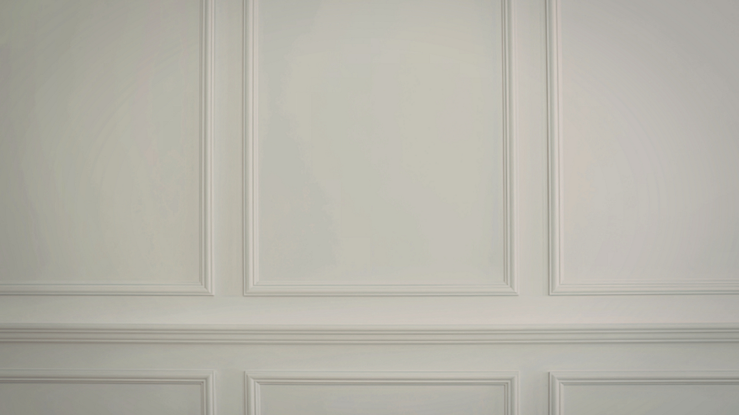 A wall featuring classic white rectangular wainscoting paneling.