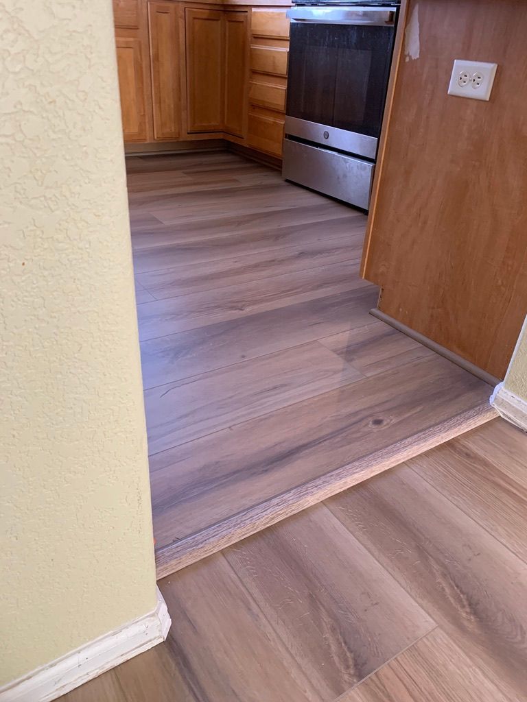 A kitchen with hardwood floors and a stainless steel stove.