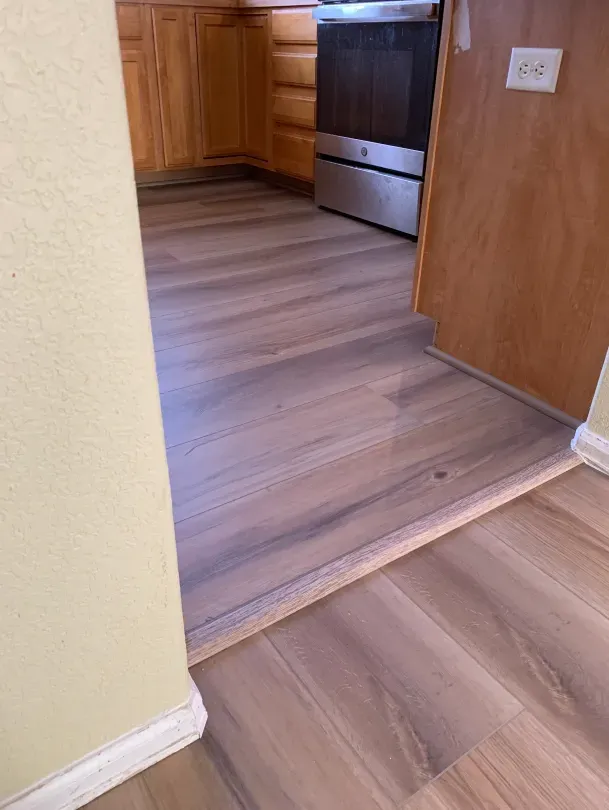 A kitchen with hardwood floors and a stainless steel stove.
