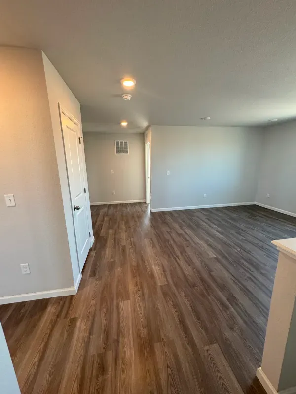 A living room with hardwood floors and white walls.