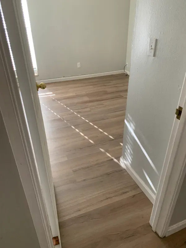 A room with hardwood floors and white walls.
