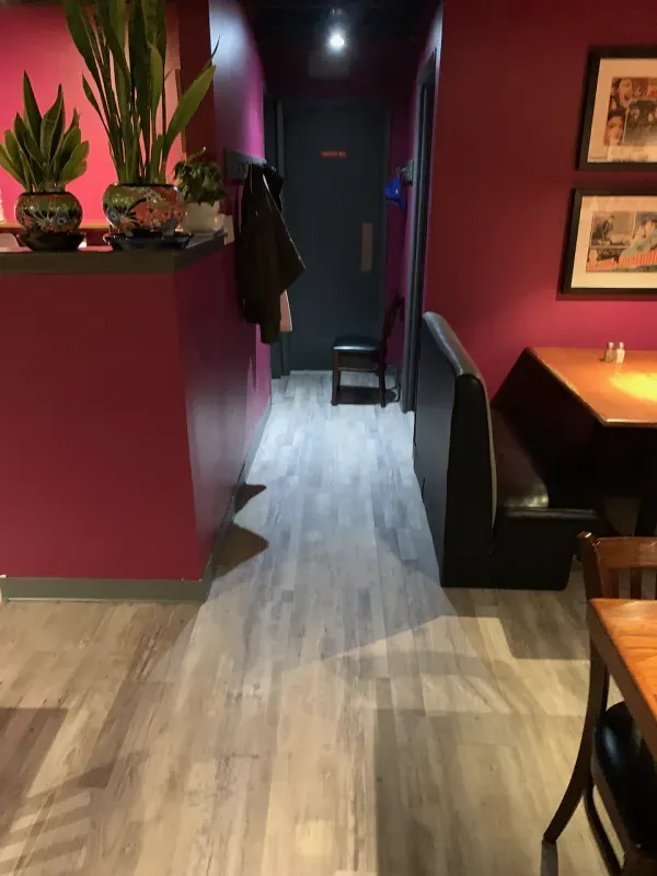 A hallway in a restaurant with tables and chairs