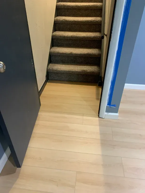 A staircase with carpeted steps leading up to the second floor of a house.