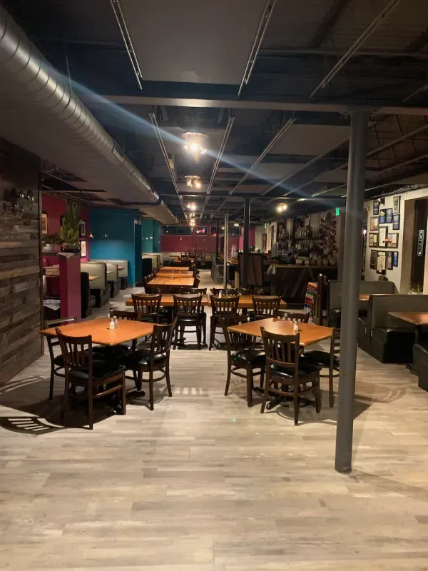 A restaurant with tables and chairs in a large room.