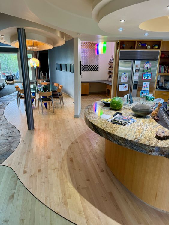 A kitchen with a round island and granite counter tops