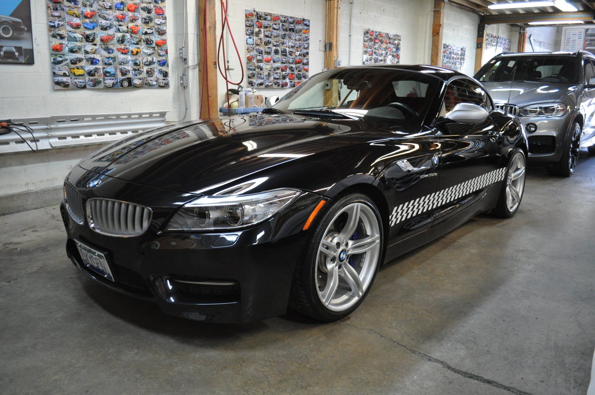 A black bmw z4 is parked in a garage.