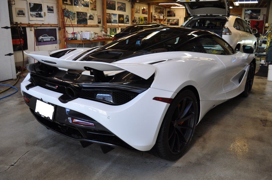 A white and black sports car is parked in a garage.
