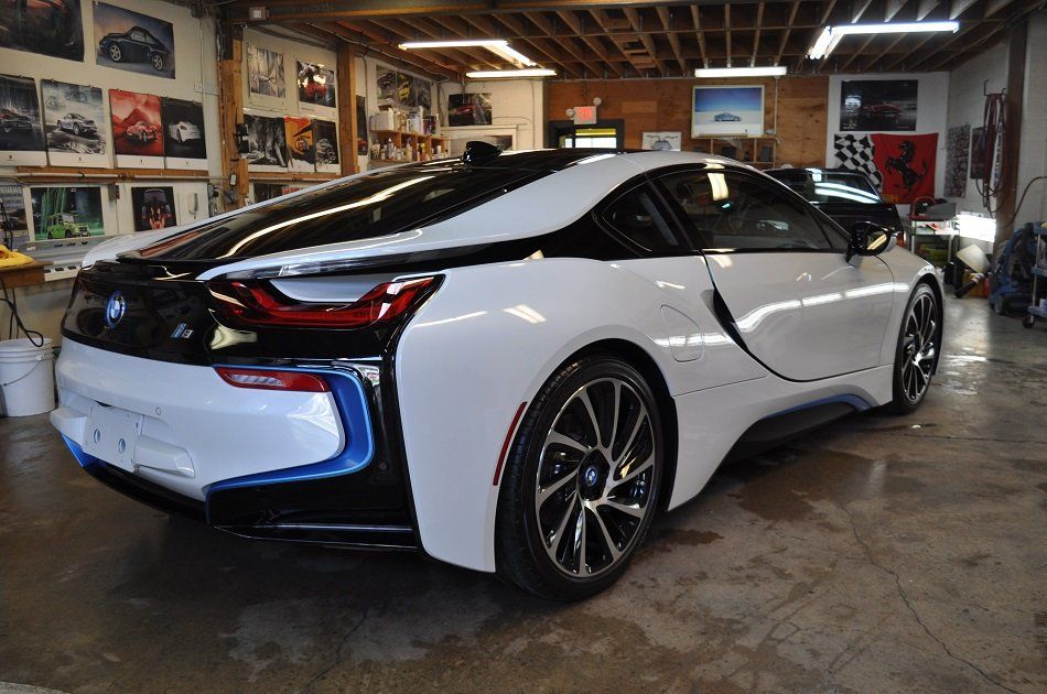 A white bmw i8 is parked in a garage.
