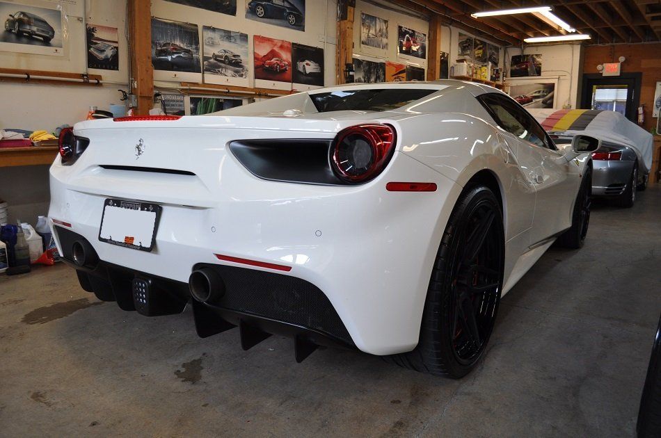 A white ferrari sports car is parked in a garage