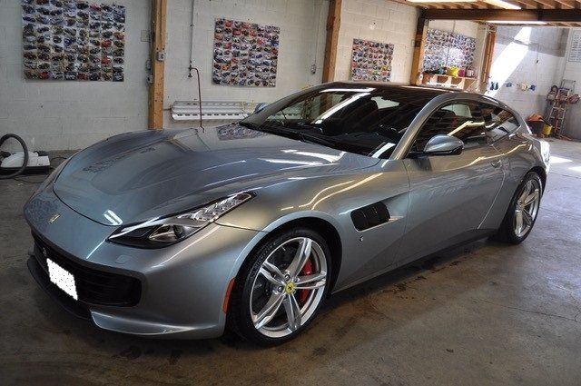 A silver sports car is parked in a garage.