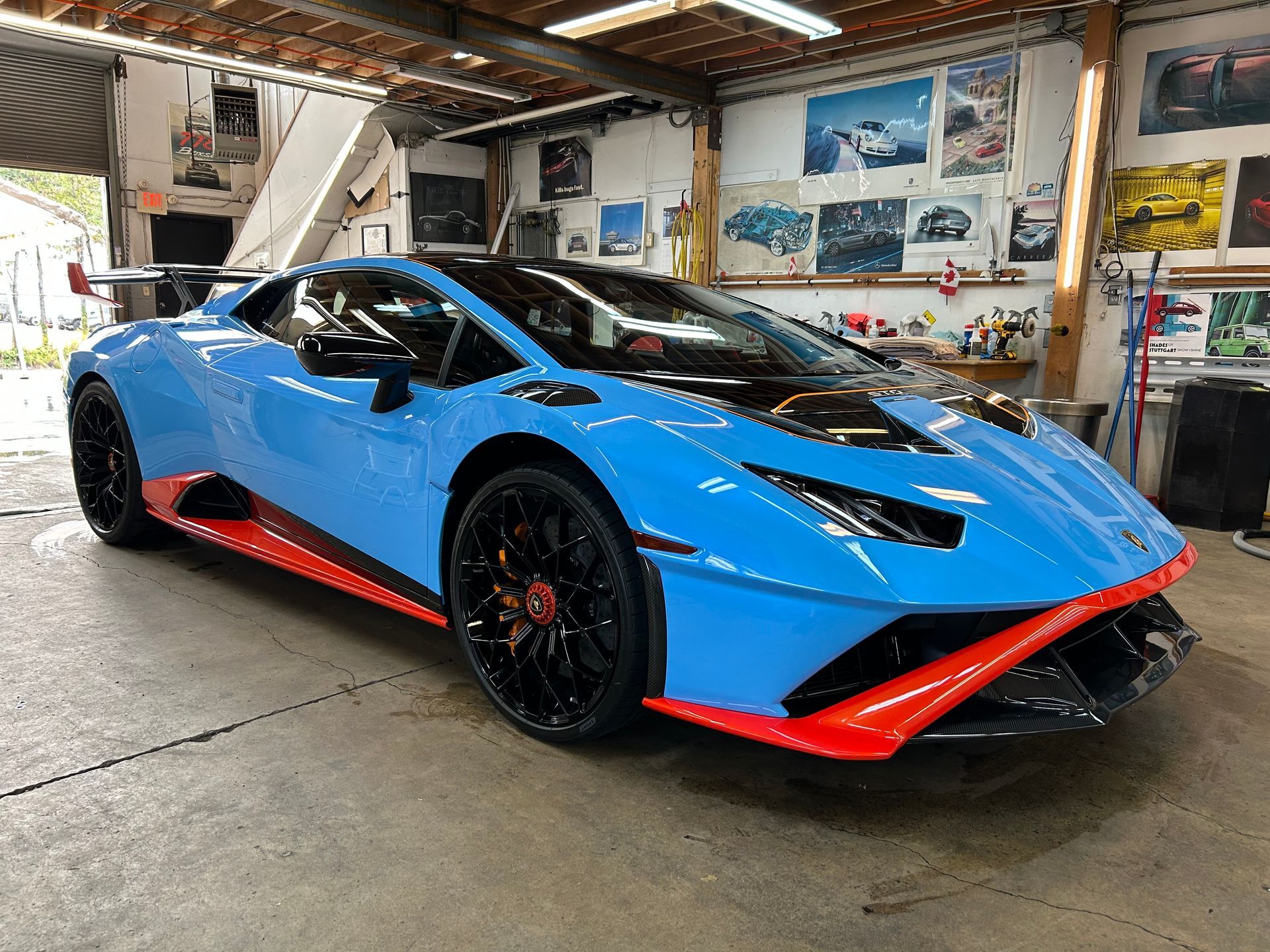 A blue lamborghini huracan is parked in a garage.