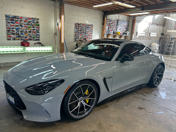 A gray sports car is parked in a garage.