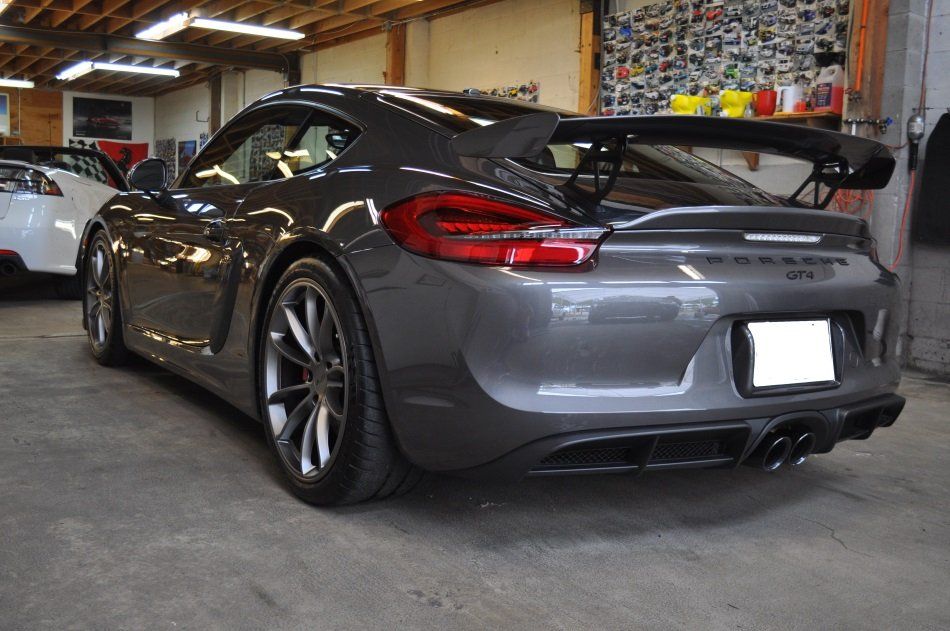 A gray sports car is parked in a garage.