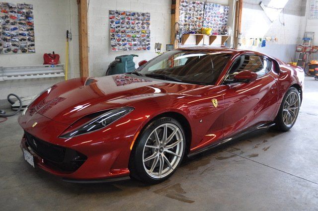 A red ferrari is parked in a garage.
