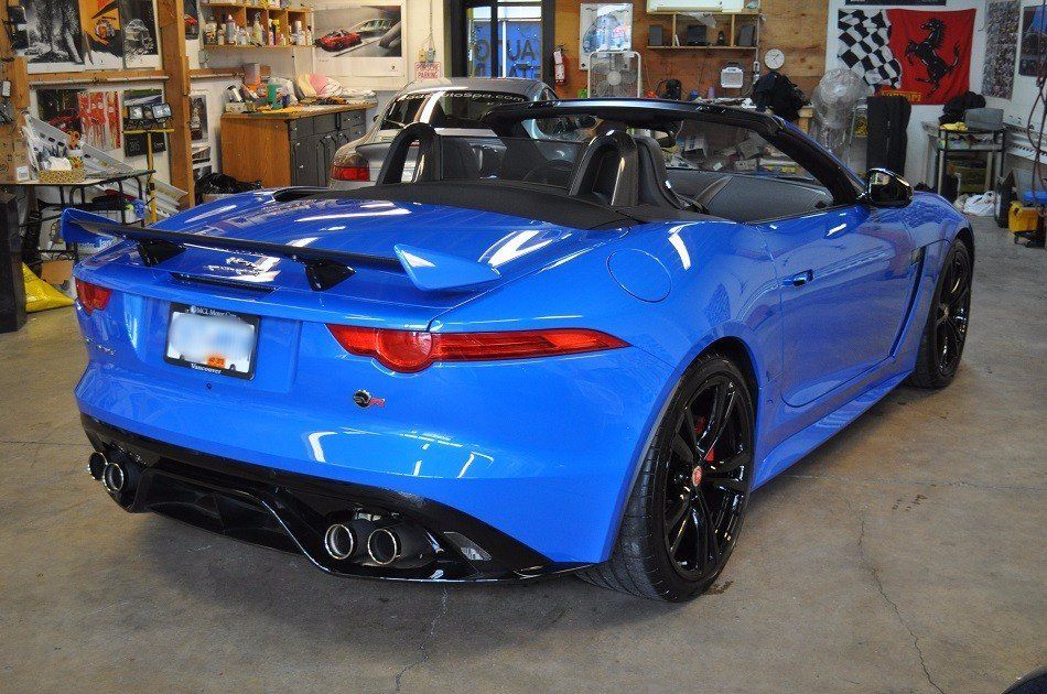 A blue sports car is parked in a garage