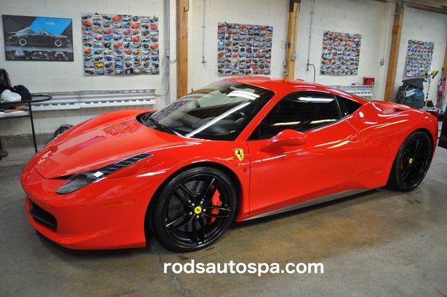 A red ferrari sports car is parked in a garage