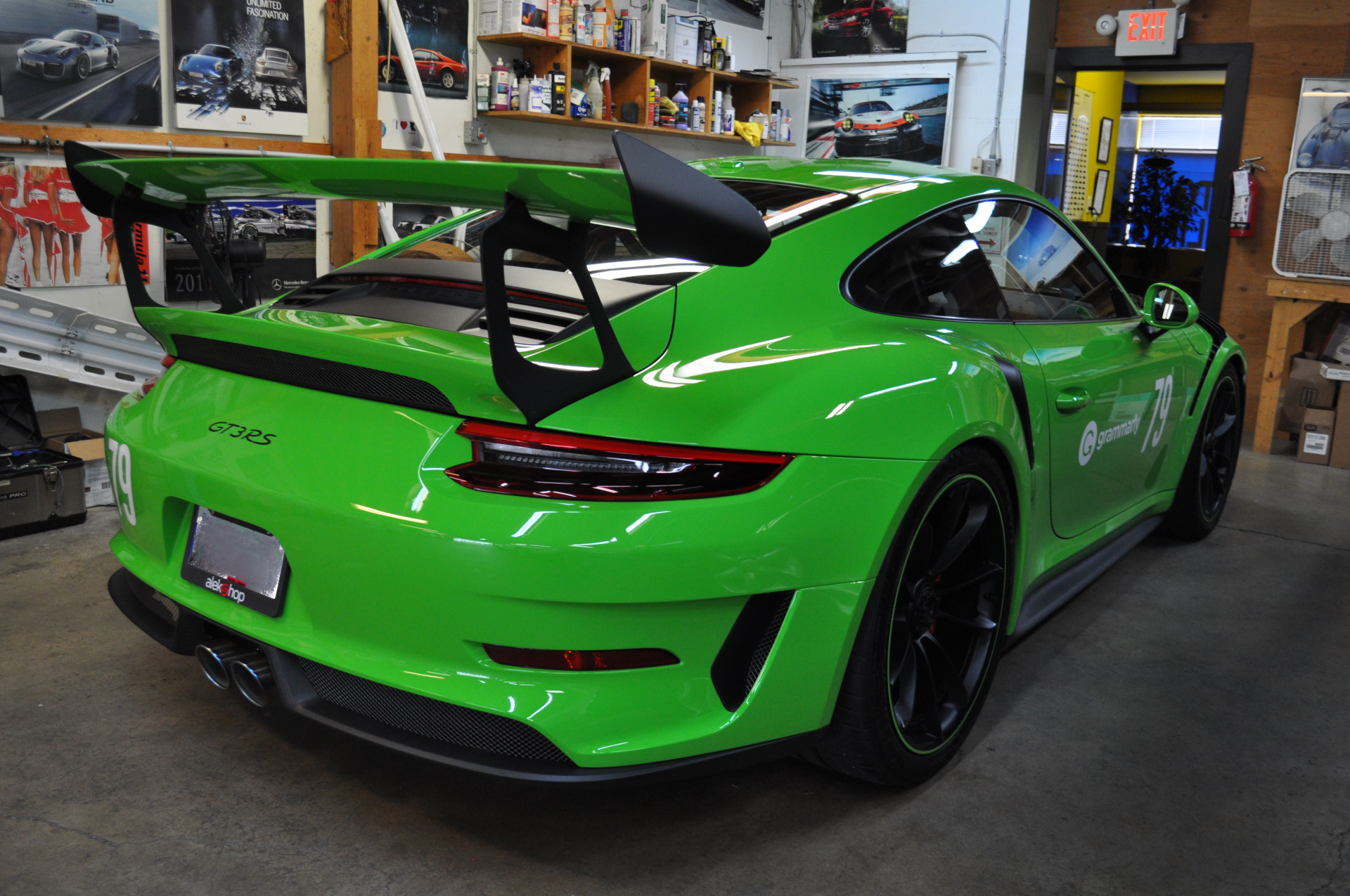 A green porsche 911 gt3 rs is parked in a garage.