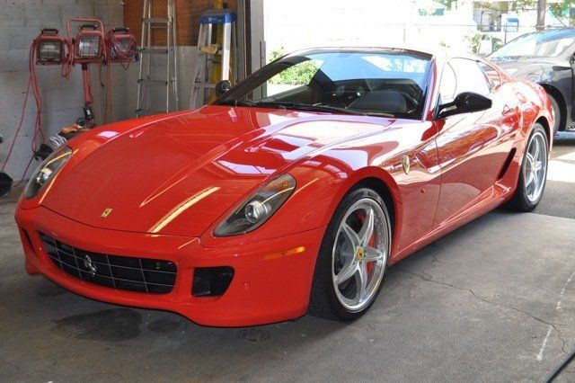 A red ferrari sports car is parked in a garage