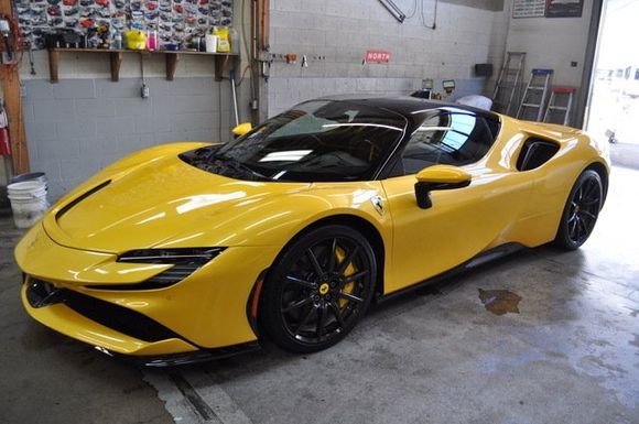 A yellow sports car is parked in a garage.