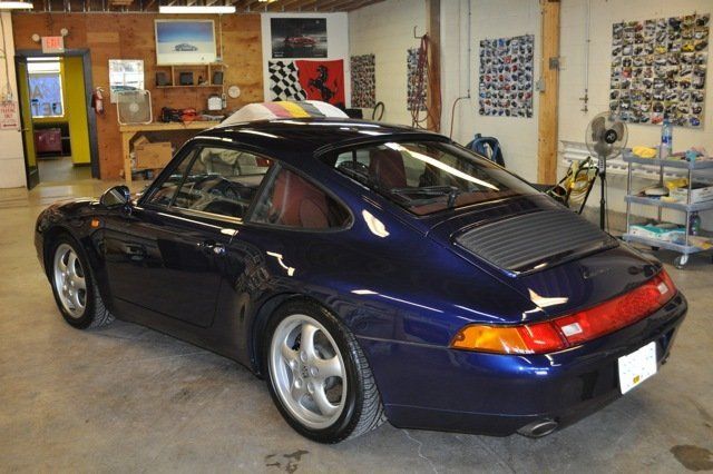A blue porsche is parked in a garage