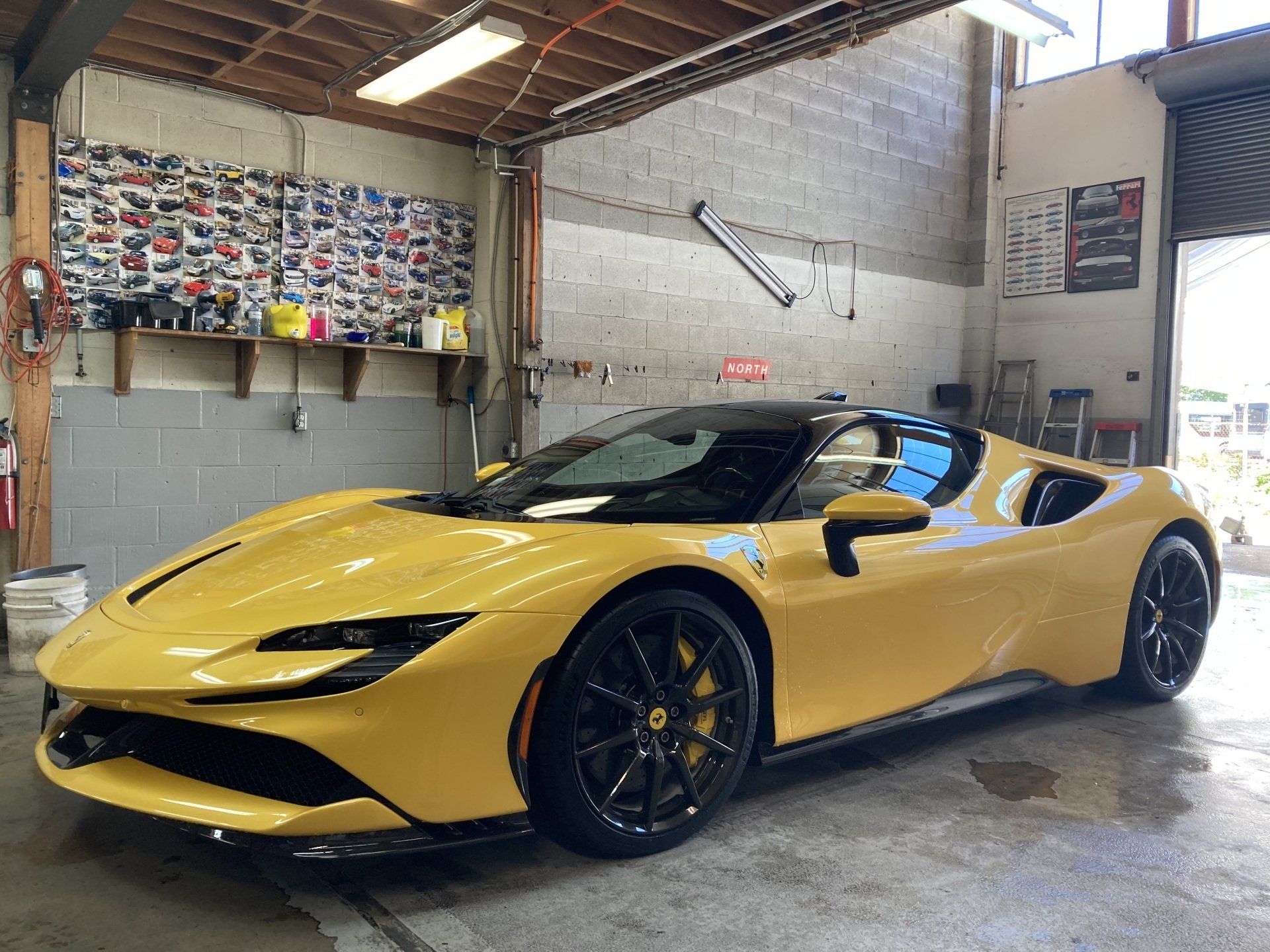 A yellow sports car is parked in a garage.