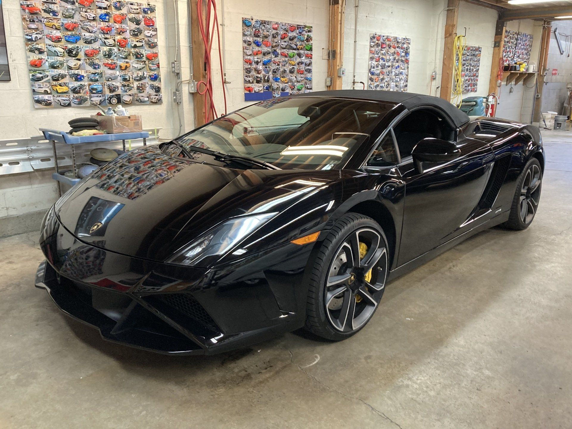 A black lamborghini gallardo is parked in a garage.