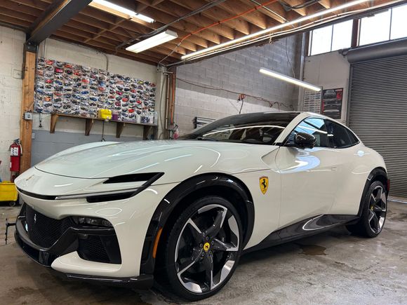 A gray sports car is parked in a garage.