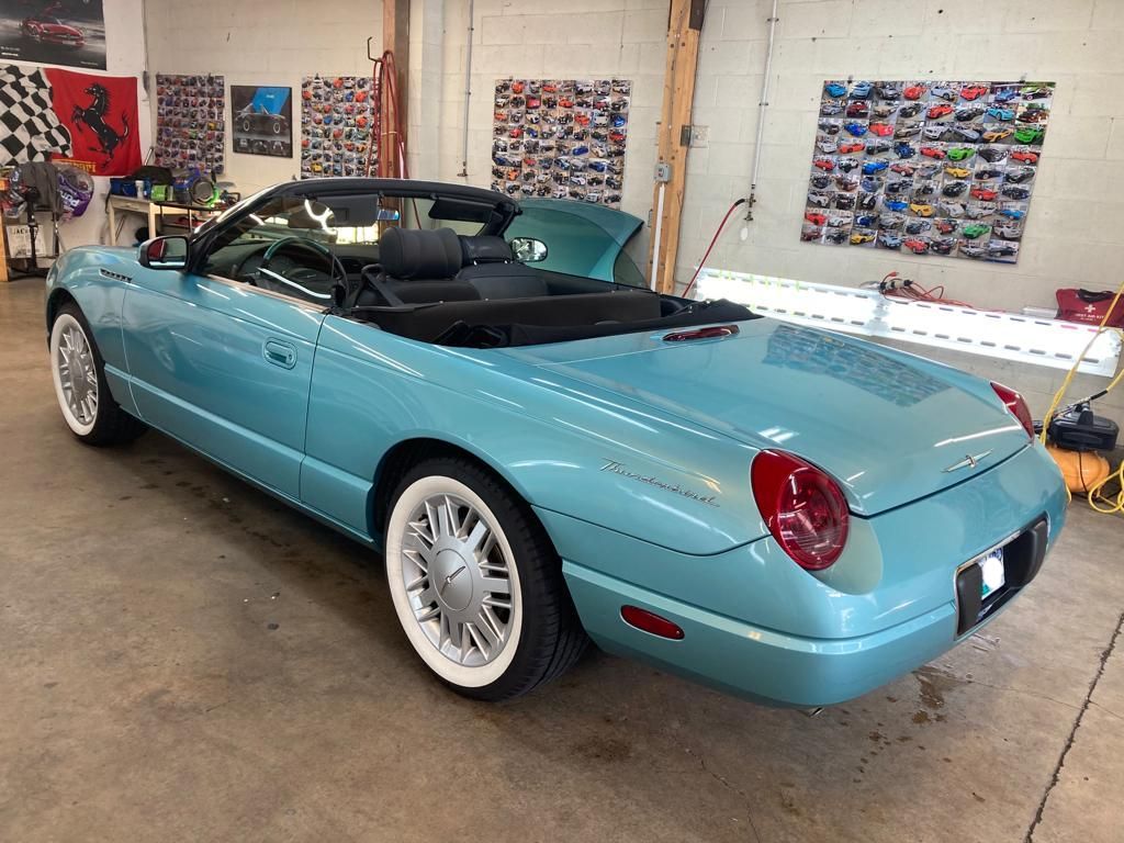 A light blue convertible is parked in a garage.