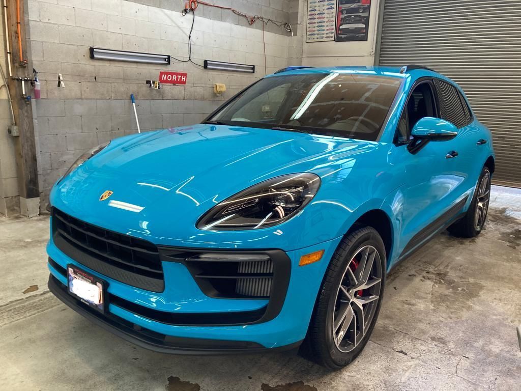 A blue porsche macan turbo is parked in a garage.