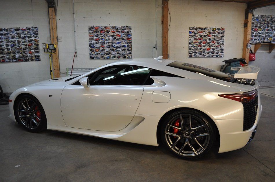 A white sports car is parked in a garage.