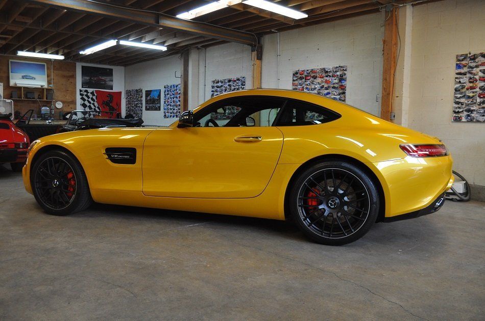 A yellow sports car is parked in a garage.