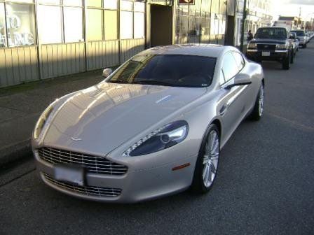 A silver sports car is parked on the side of the road