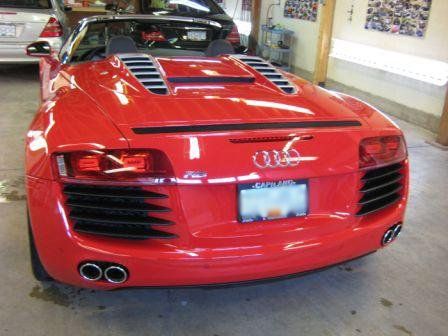 A red audi sports car is parked in a garage