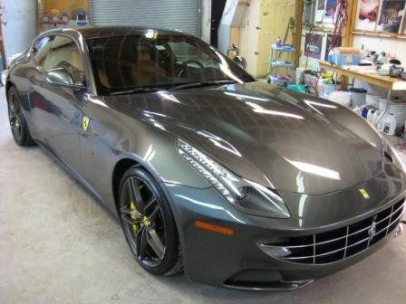 A gray ferrari sports car is parked in a garage