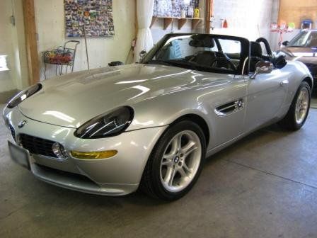A silver sports car is parked in a garage.